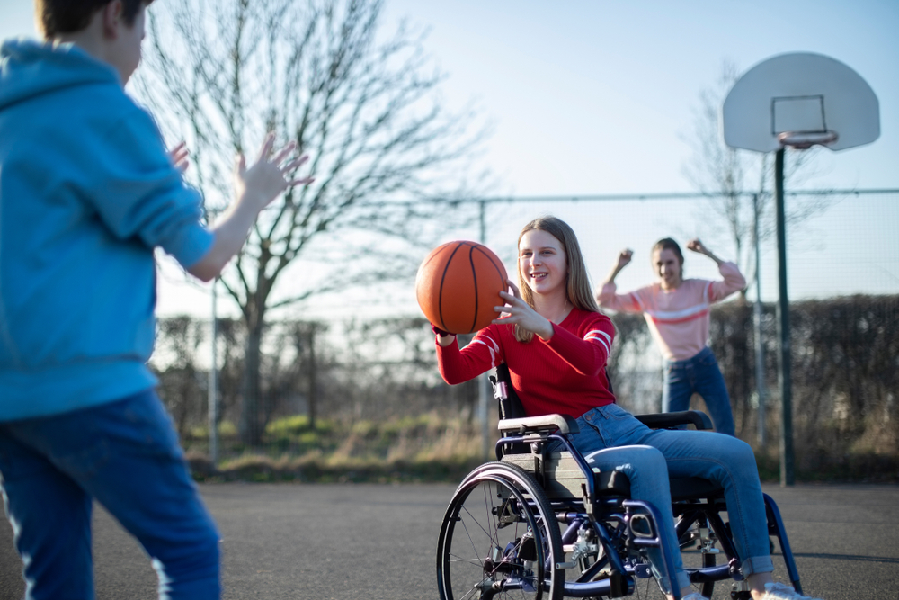 Young girl in wheelchair playing basketball