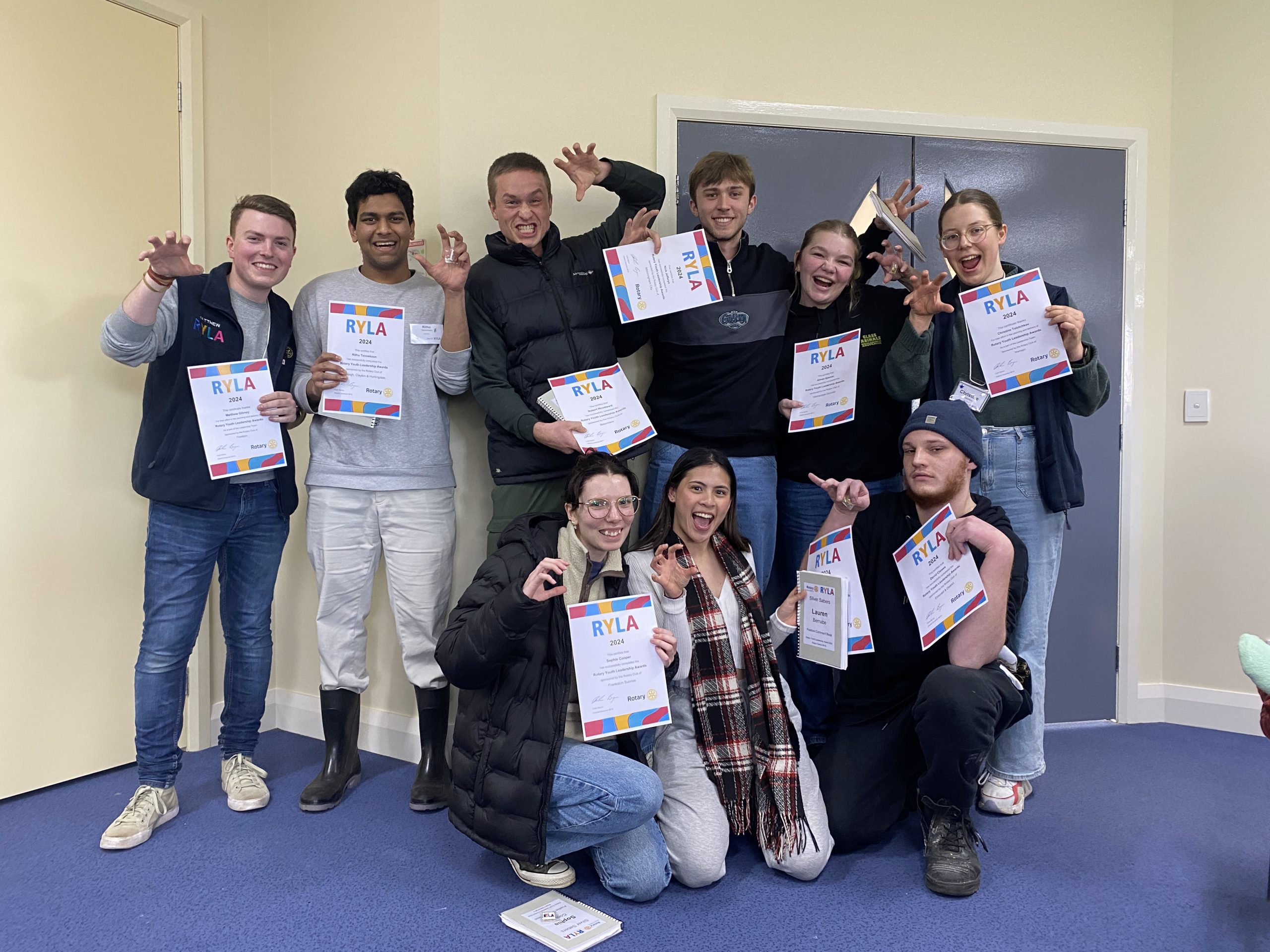 A group of young people, smiling and posing while holding certificates